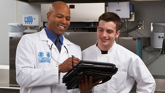 Ecolab Representative Speaking to a Chef about Apex Results EcolabRepspeakingwChefaboutApexresults