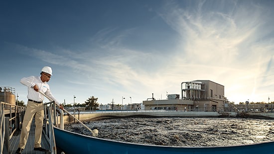 Worker treating wastewater at manufacturing facility