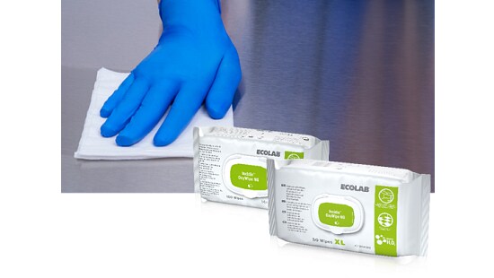 Person in blue glove wiping a surface with a cloth, with two packages of Ecolab Indur OxyWipe NG disinfectant wipes in the foreground.