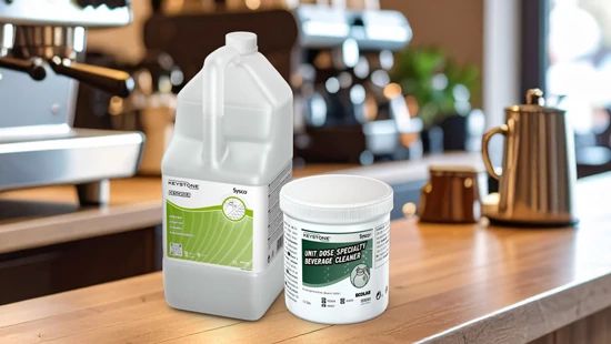 Keystone Descaler & Unit Dose Beverage Cleaner Tablets sat on a coffee shop counter top with a coffee machine in the background